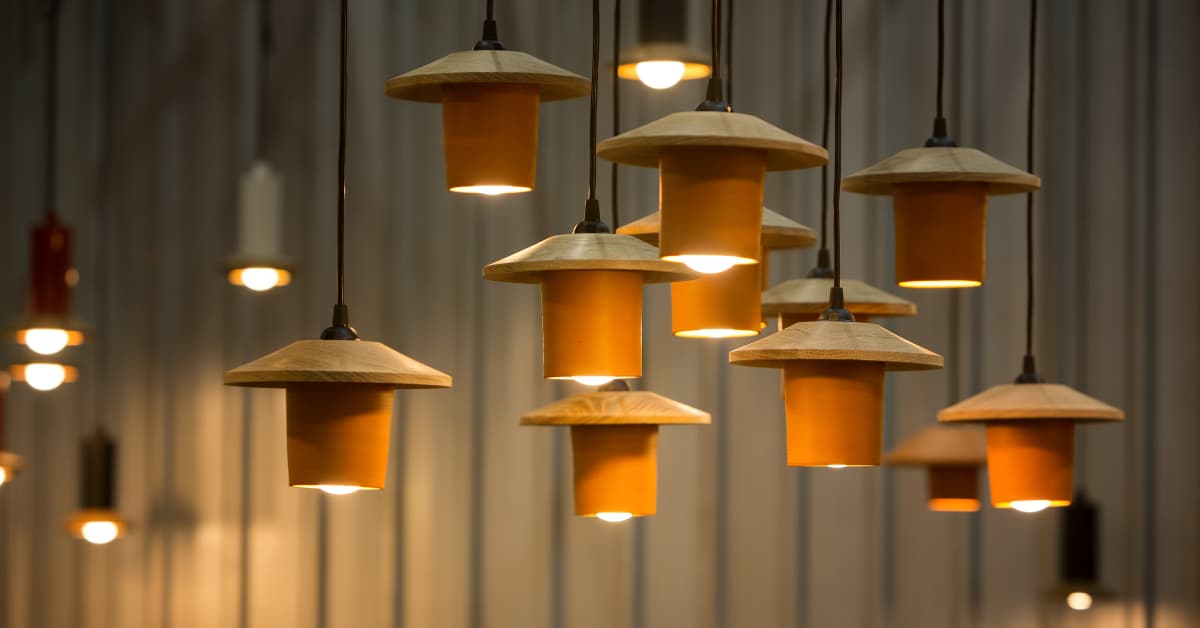 Lámparas de cartón colgantes con diseño artesanal y luz cálida.